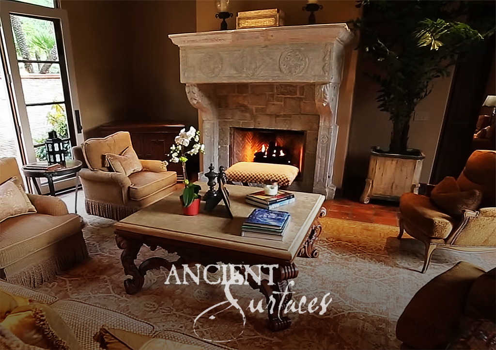 Monumental carved limestone fireplace with corbels and floral medallions in the living room at Puerta Del Sol